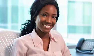 Medical Office Administrator Smiling at Desk